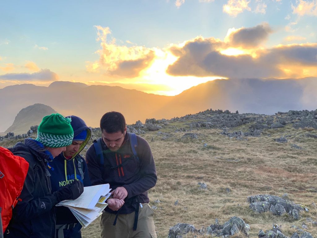 Instructor teaching map reading and compass navigation during an outdoor hill walking course.